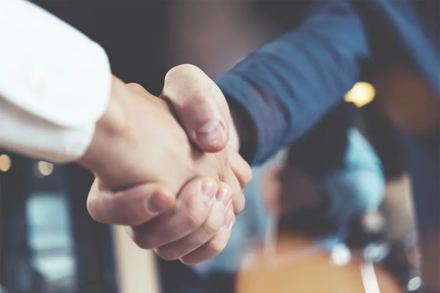 Two people shaking hands after agreeing a window covering project